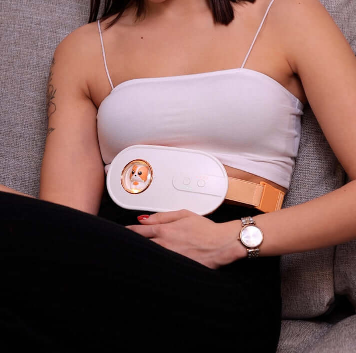 Woman using WarmWave™ heater and massager for period cramps, showcasing ZIMOKE beauty and health care innovation.